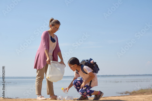Daughter and mother collected plastic bottles by the lake together