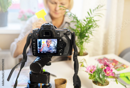 Florist video blog. Woman uses a camera to broadcast an online tutorial on home gardening.
