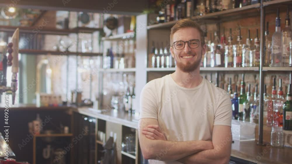 Portrait of smiling male member of bar staff behind counter - shot in slow motion Portrait of smiling male member of bar staff behind counter - shot in slow motion