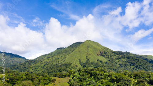 Summer mountains green grass and blue sky landscape. Mountain landscape with green hills and mountains with forest. Philippines, Luzon.