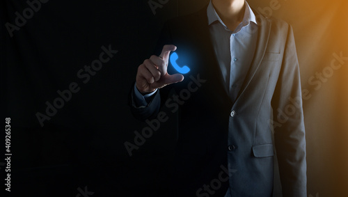 Businessman in suit on black background clicks on phone icon.Call Now Business Communication Support Center Customer Service Technology Concept.