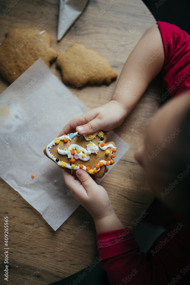 Little girl holding decorated cookie from above. Little girl holding decorated cookie from above.