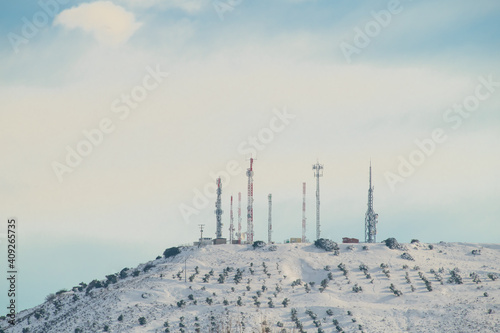 Group of telecommunications antennas on snowy mountain photo