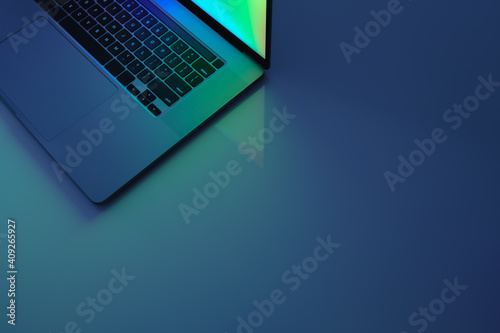 Laptop computer standing on a table, low key blue light image. C