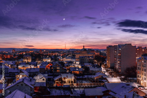 Evening sky over the winter city. Incredible color of the sky at sunset. Illuminated evening city