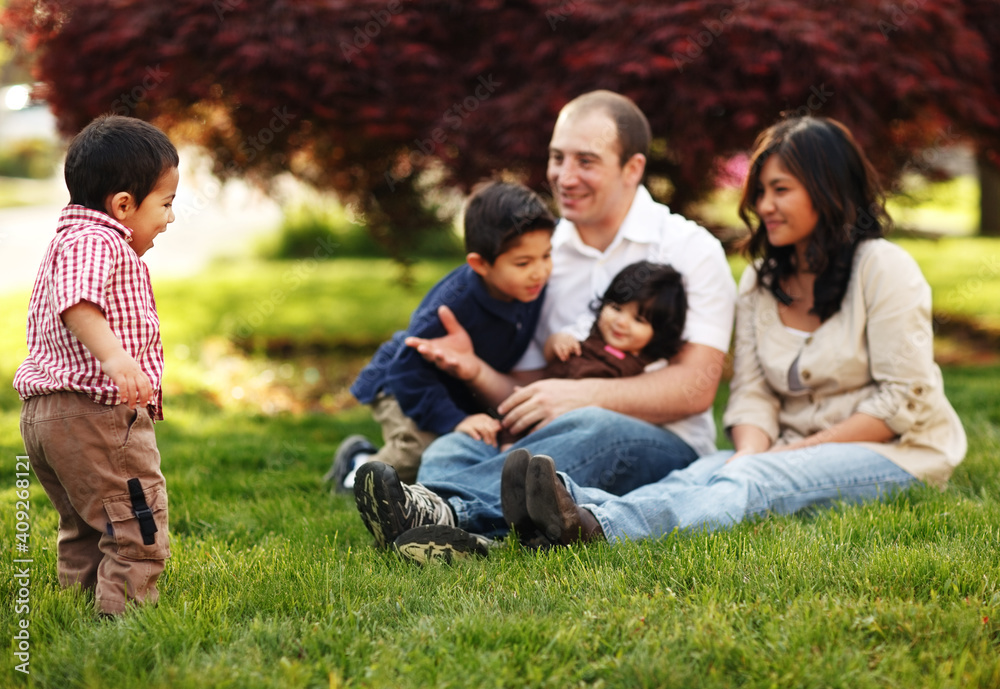 Familiy sitting in the grass in park Familiy sitting in the grass in park