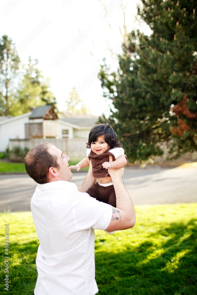 Father holding up daughter in air in park Father holding up daughter in air in park