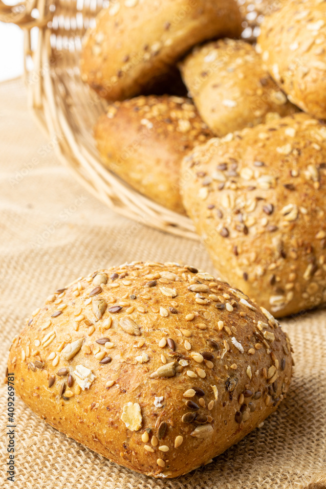 Sliced Multigrain. Rye bakery with crusty loaves and crumbs. Fresh loaf of rustic traditional bread with wheat grain ear or spike plant on natural cotton background. Bio ingredients, very healthy.