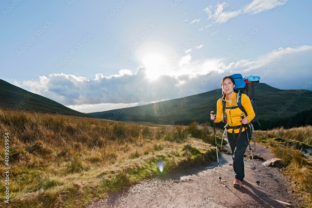 female hiker walking up towards Pen Y Fan in Wales female hiker walking up towards Pen Y Fan in Wales