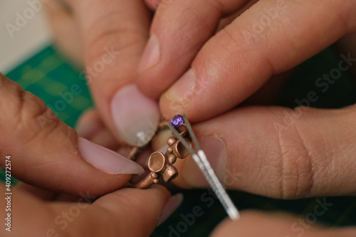 Macro shot. Craft jewelery making. Ring repairing. Putting the diamond on the ring. Desktop for craft jewellery making with professional tools.