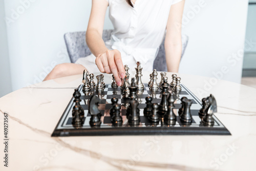 Concept of Strategy in business : A Woman playing a chess game