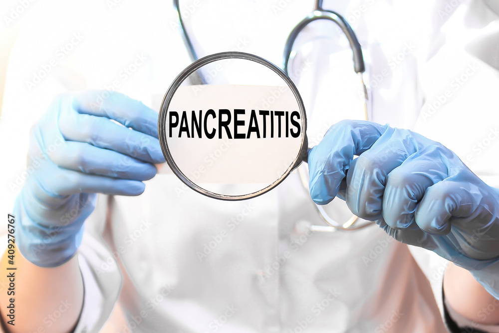 The doctor's blue - gloved hands show the word PANCREATITIS - . a gloved hand on a white background. Medical concept. the medicine