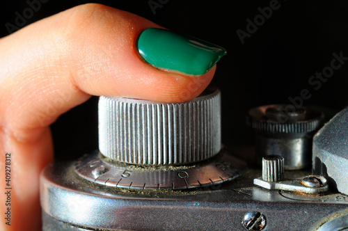 Obraz na plátně Woman finger pressing shutter release button of an old dusty film camera