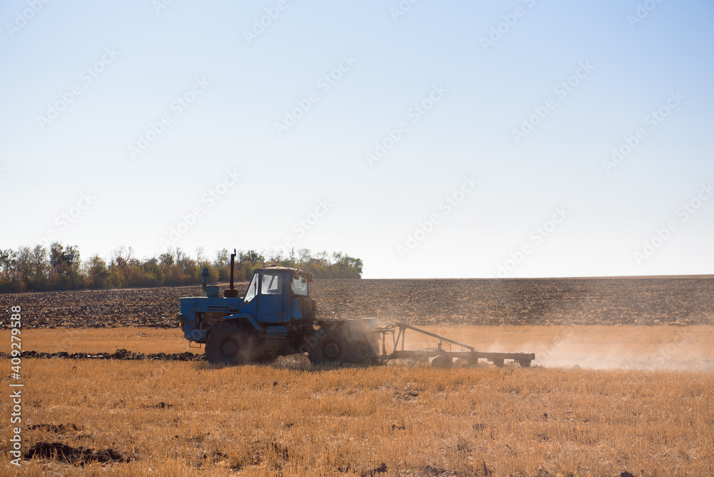Fototapeta premium Farmer preparing his field in a tractor ready for spring.