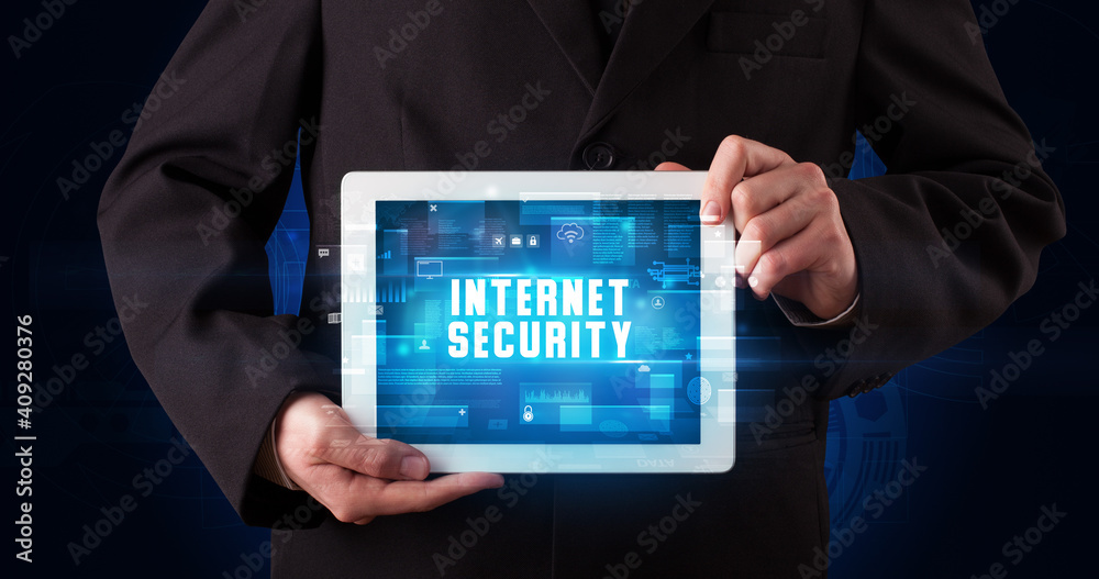 Young business person working on tablet and shows the digital sign: INTERNET SECURITY Young business person working on tablet and shows the digital sign: INTERNET SECURITY