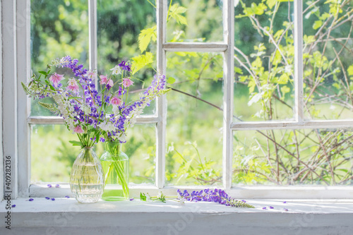 Fototapeta Naklejka Na Ścianę i Meble -  summer flowers in vase on windowsill in sunlight