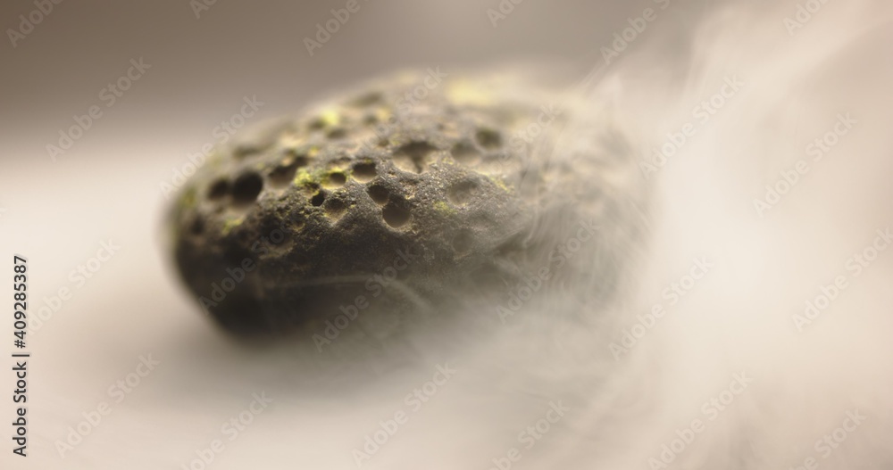 Obraz premium Smoke whirling around small meteorite stone