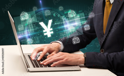 business hand working in stock market with yen icons coming out from laptop screen