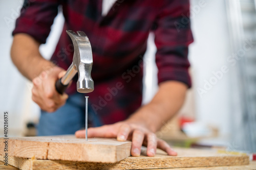 Slika na platnu Close up of hammering a nail into board