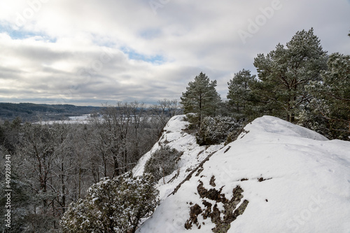 Natural winter landscape with snowy steep hillside and coniferous trees in Scandinavia photo