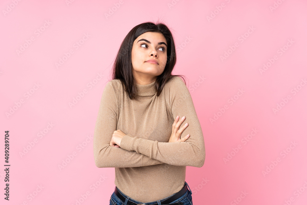 Young woman over isolated pink background making doubts gesture while lifting the shoulders Young woman over isolated pink background making doubts gesture while lifting the shoulders