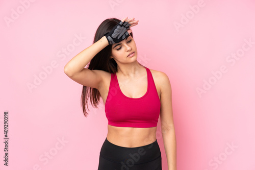 Young sport woman over isolated pink background with tired expression © luismolinero