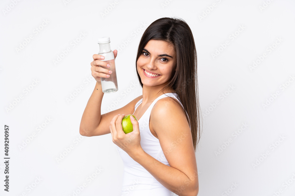 Young woman over isolated white background with an apple and with a bottle of water Young woman over isolated white background with an apple and with a bottle of water