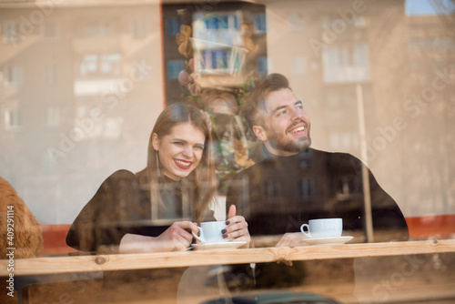 Good looking couple laughing and having a good time on a date in a coffee shop