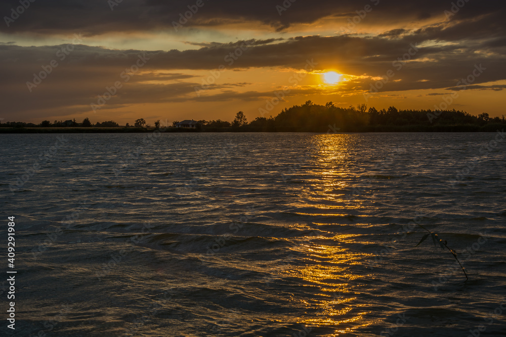 Sunset with clouds over a lake with waves