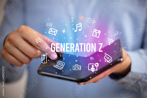 Businessman holding a foldable smartphone with GENERATION Z inscription, social media concept