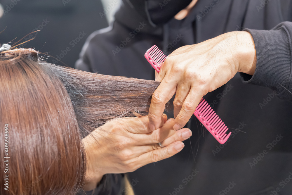 © garage38 - ヘアサロンで髪の毛をカットする美容師の手元