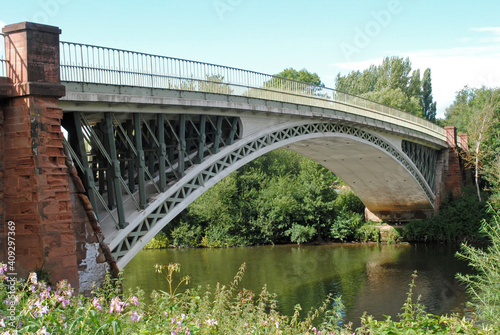 View of Old Iron Arched Bridge across Still Waters of River  © eyepals