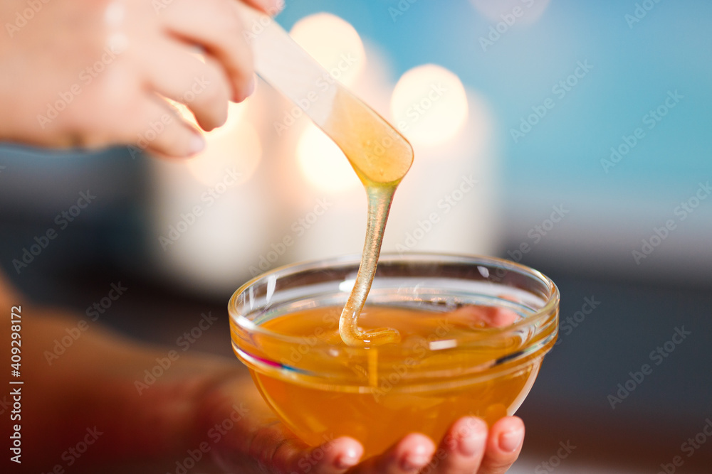 hands professional masseuse holding honey cup for spa body treatment in spa salon. masseuse prepared pure honey for facial mask. Beauty treatment and healthcare concept. hands professional masseuse holding honey cup for spa body treatment in spa salon. masseuse prepared pure honey for facial mask. Beauty treatment and healthcare concept.