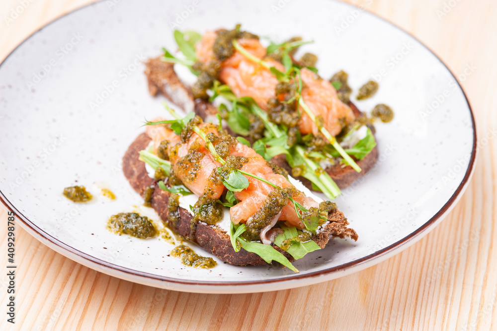 Salmon bruschetta with pesto in white plate Salmon bruschetta with pesto in white plate