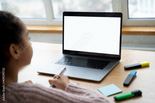 Mockup on laptop with young girl watching online lessons.