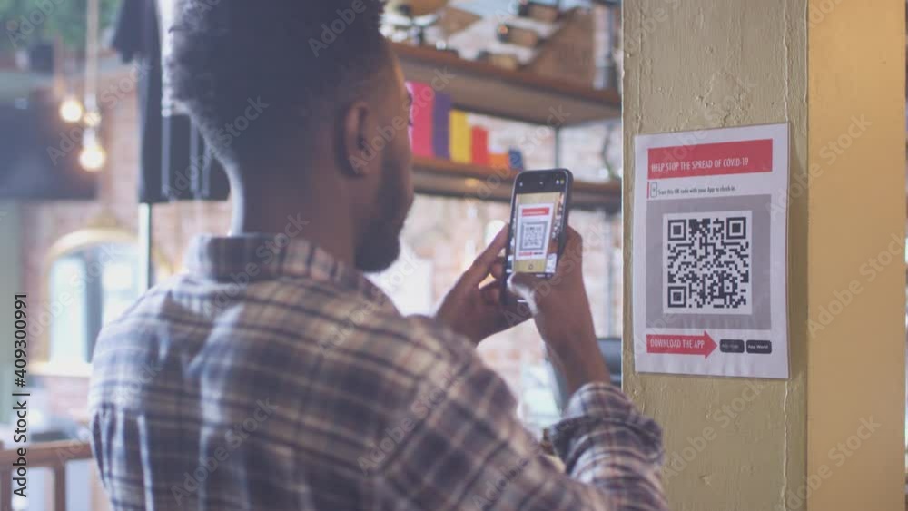 Man with mobile phone checking into venue scanning QR code during health pandemic - shot in slow motion
