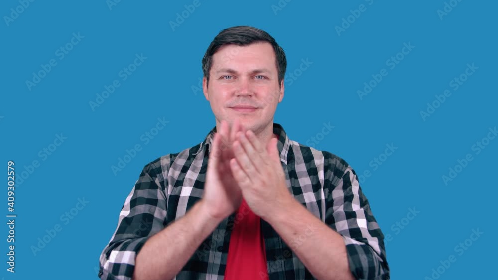 Handsome man on blue background claps his hands and applauds happy and joyful, smiling proud hands together. Handsome man on blue background claps his hands and applauds happy and joyful, smiling proud hands together.