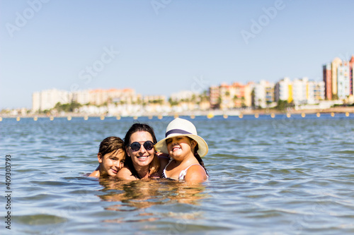 mother embracing her children in the sea