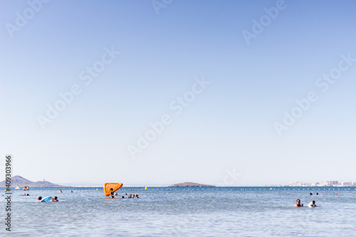 group of people bathing in the sea in the distance