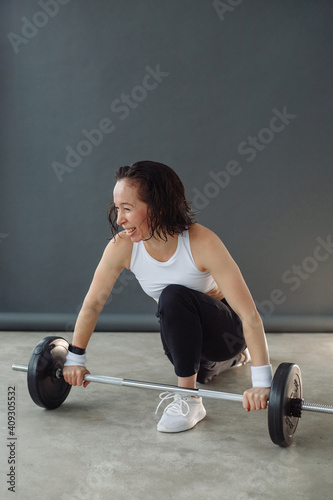 Young woman and fitness training with heavy weight. A sporty image of a woman in black and white