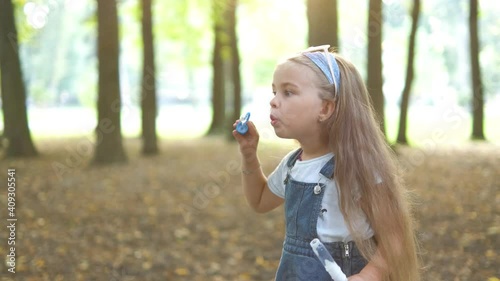 Wallpaper Mural Little happy child girl blowing soap bubbles outside in green park. Outdoor summer activities concept. Torontodigital.ca