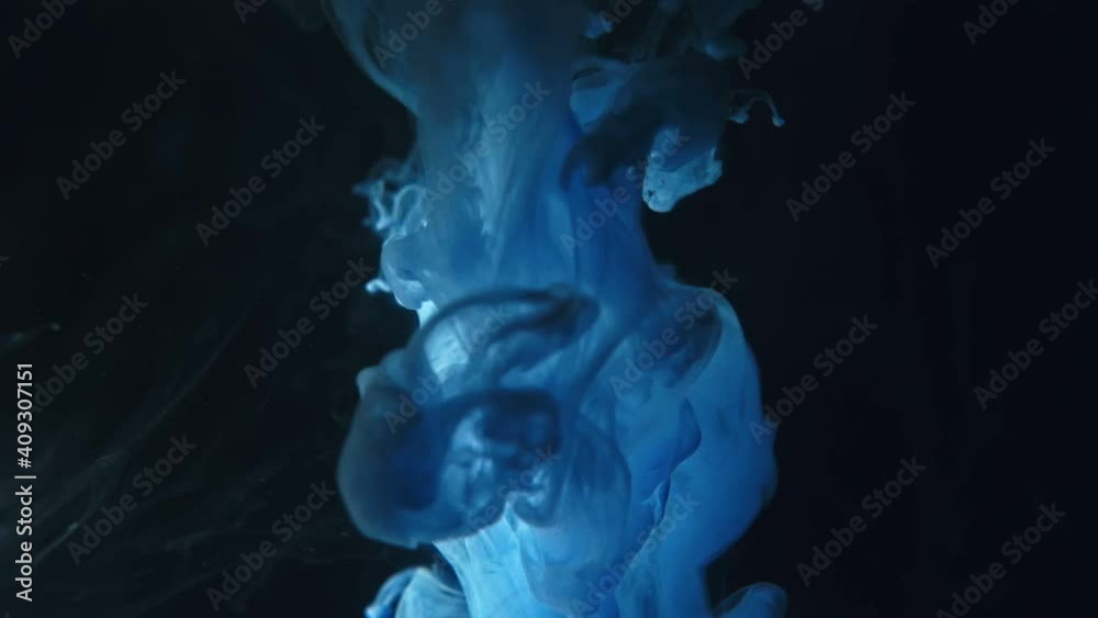 Blue paint drops mixing in water slow motion. Smooth ink swirling and splashing from above underwater. Ink cloud on black background. Colored abstract smoke explosion. Blue paint drops mixing in water slow motion. Smooth ink swirling and splashing from above underwater. Ink cloud on black background. Colored abstract smoke explosion.