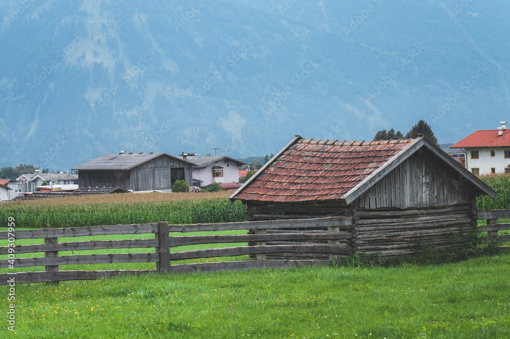 old wooden barn with mountains in a background (Mieming, Austria)