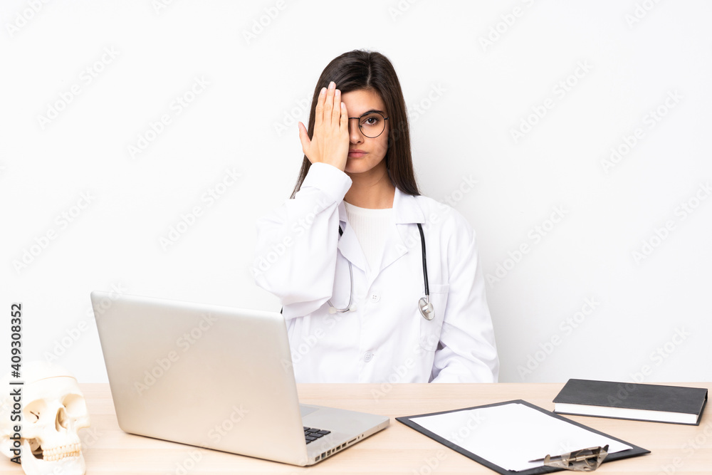 Professional traumatologist in workplace covering a eye by hand Professional traumatologist in workplace covering a eye by hand