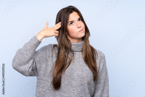 Teenager Brazilian girl over isolated blue background with problems making suicide gesture