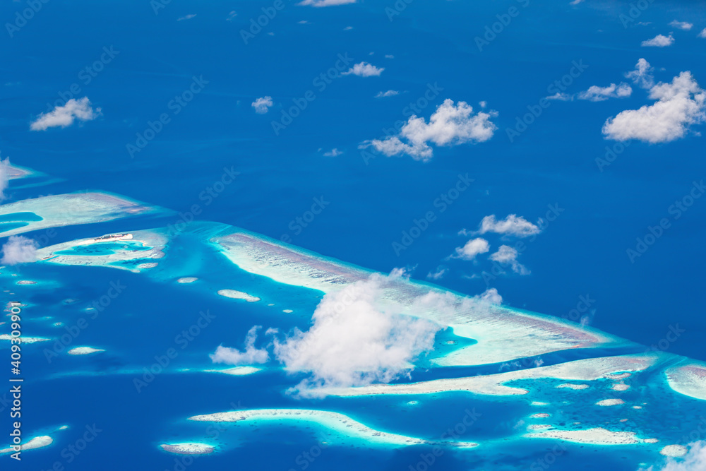 Window view from airplane on maldivian atoll with islands