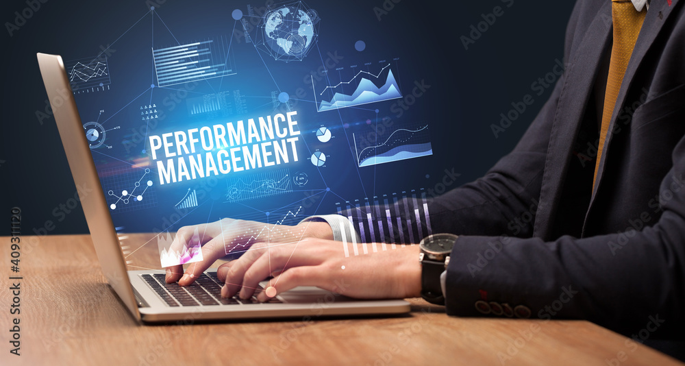 Businessman working on laptop with PERFORMANCE MANAGEMENT inscription, new business concept Businessman working on laptop with PERFORMANCE MANAGEMENT inscription, new business concept