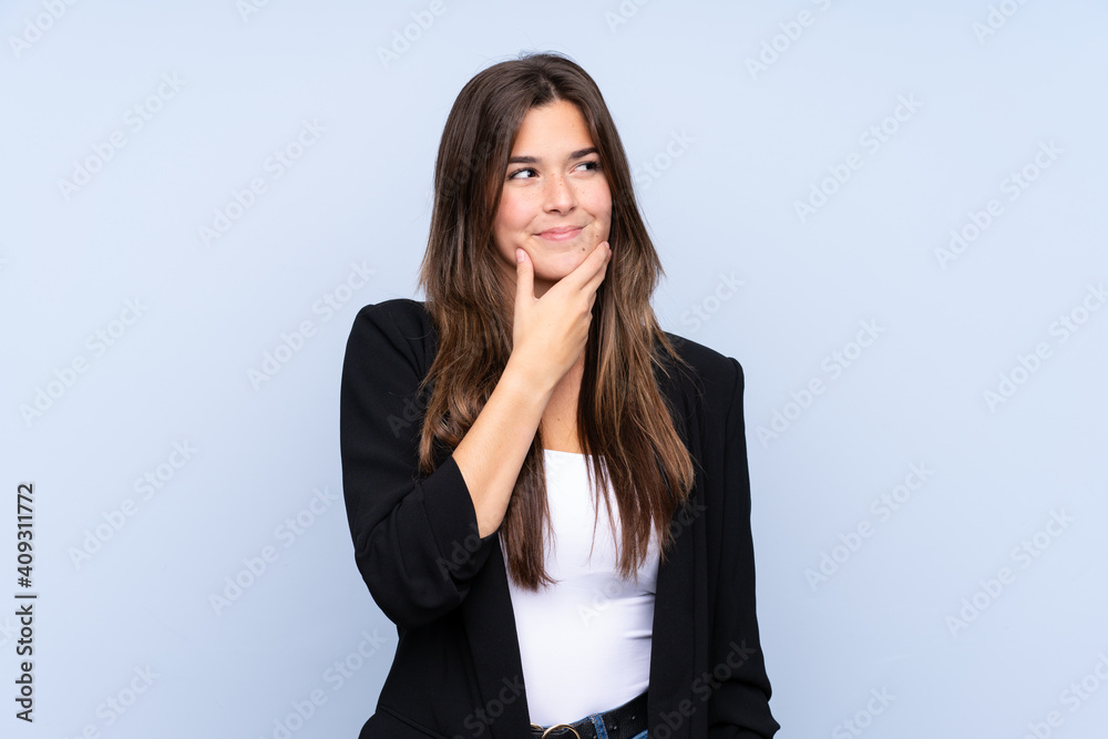 Young Brazilian business woman over isolated blue background thinking an idea Young Brazilian business woman over isolated blue background thinking an idea