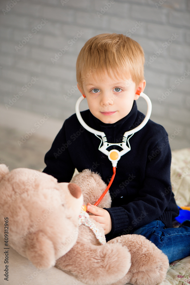 Child playing doctor with a toy. Pediatrician for preschool and kindergarten kids. Pediatric, healthcare and people concept Child playing doctor with a toy. Pediatrician for preschool and kindergarten kids. Pediatric, healthcare and people concept
