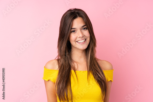 Teenager Brazilian girl over isolated pink background laughing